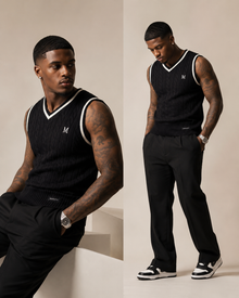 Madasty Signature Cable-Knit Vest

A timeless layering piece designed for polished, effortless style. This black cable-knit vest features crisp cream trim along the V-neck and armholes, a delicate embroidered M on the chest, and a subtle Madasty label at